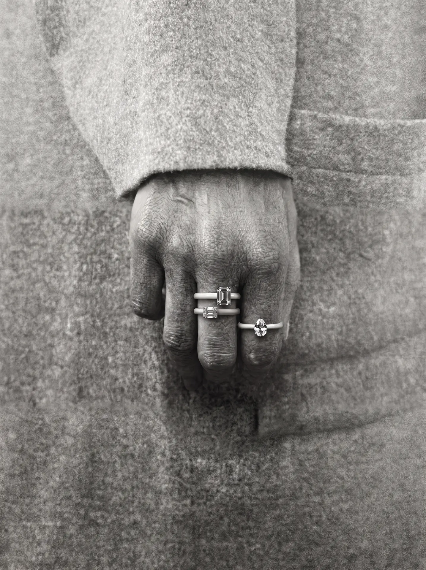 Hand wearing enamel gemstone rings in black and white